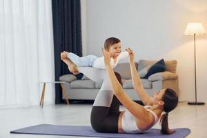 vrouw houdende naar beneden Aan mat en Holding weinig meisje. moeder met haar weinig dochter is Bij huis samen foto