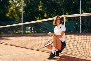 in de buurt de netto. vrouw tennis speler is Aan de rechtbank Bij dag foto