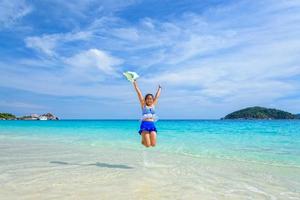 meisje jumping met gelukkig Aan de strand Bij Thailand foto