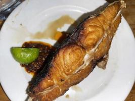 heerlijk gebakken Spaans makreel vis met pittig saus en citrus geserveerd Aan wit bord foto
