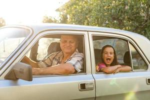 weinig meisje looks uit van opa auto venster foto