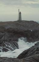 vuurtoren mijlpaal Aan rotsachtig kust landschap foto