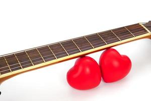 akoestisch gitaar nek en rood hart tegen wit achtergrond. liefde en muziek- concept. foto