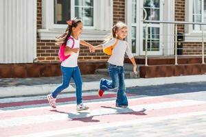 twee schoolmeisjes Gaan naar school. de concept van school, studie, opleiding, vriendschap, jeugd. foto