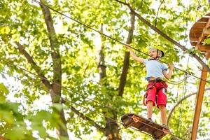 gelukkig weinig kinderen in een touw park Aan de hout achtergrond foto