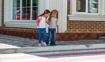 twee schoolmeisjes Gaan naar school. de concept van school, studie, opleiding, vriendschap, jeugd. foto