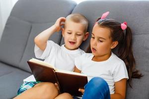 kinderen lezen een boek Bij huis foto