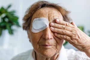 ouderen vrouw met een oog chirurgie foto