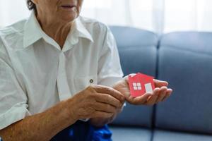 senior vrouw houdt de lay-out van de huis in haar handen foto