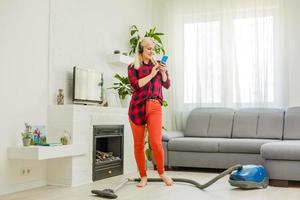 vrouw schoonmaak verdieping vacuüm schoonmaakster in de modern wit leven kamer foto