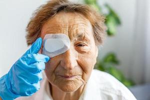 ouderen vrouw met een oog chirurgie foto