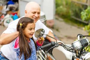 gelukkig opa en zijn kleindochter in de buurt fiets glimlachen foto