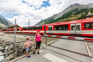 familie wandelen wandelen spoor in bergen in zomer, Alpen trein foto