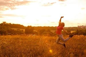 gelukkig vrouw leven Bij zonsondergang in de geel veld- foto