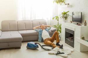 coronavirus pandemie. een Mens met een vacuüm schoonmaakster in zijn appartement. huis kantoor. quarantaine. afgelegen werk. een Mens in een bedrijf overhemd en onderbroek houdt. foto