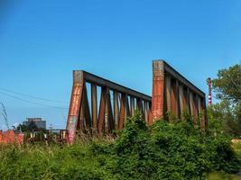 oud roestig brug over- de rivier. vervoer. oud metaal spoorweg brug. staal brug aan de overkant de rivier- tegen blauw lucht. foto