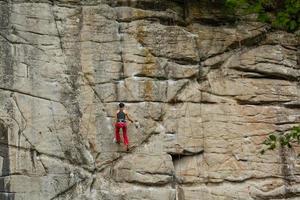 een jong vrouw met een touw verloofd in de sport- van rots beklimming foto