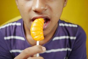 jongen aan het eten lolly dichtbij omhoog foto