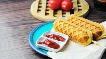 wafel stokjes maïs honden heet hond wafels Aan een stok ketchup Aan een houten tafel foto