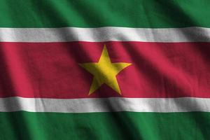 Suriname vlag met groot vouwen golvend dichtbij omhoog onder de studio licht binnenshuis. de officieel symbolen en kleuren in banier foto