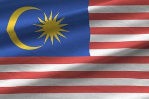 Maleisië vlag met groot vouwen golvend dichtbij omhoog onder de studio licht binnenshuis. de officieel symbolen en kleuren in banier foto