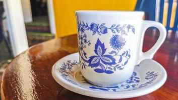 blauw wit kop pot met zwart koffie houten tafel Mexico. foto