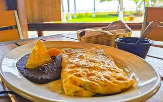 Mexicaans omelet eieren zwart bonen aardappelen nacho's Aan wit bord. foto