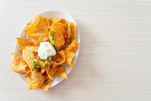 nachos tortillachips met jalapeno, guacamole, tomatensalsa en dip foto