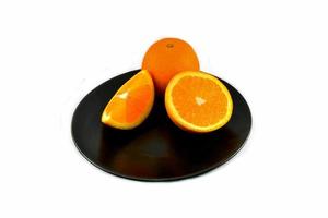 vers oranje fruit plak Aan zwart bord isoleren Aan wit achtergrond foto