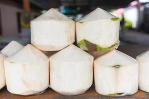 kokoswit voor sapdrank - verse jonge kokosnoot op houten tafelachtergrond foto