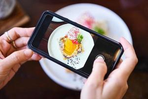 voedsel fotografie vrouw handen maken foto taart met smartphone - nemen foto voedsel voor post en delen Aan sociaal netwerken met camera slim telefoon in restaurant