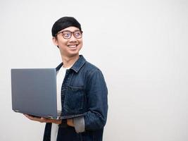 vrolijk Mens jeans overhemd Holding laptop beurt gezicht op zoek Bij kopiëren ruimte geïsoleerd foto