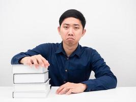 Aziatisch Mens gevoel verveeld over lezing boeken Aan de tafel wit achtergrond foto