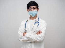 dokter vervelend medisch masker en bril staand kruis arm portret foto