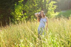 vrouw wandelen in een veld- in zomer zonnig dag. foto