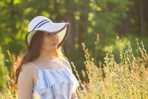 vrouw wandelen in een veld- in zomer zonnig dag. kopiëren ruimte foto