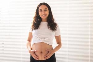 zwanger vrouw aanraken haar buik, kopiëren ruimte. zwangerschap en moederschap vertrekken foto