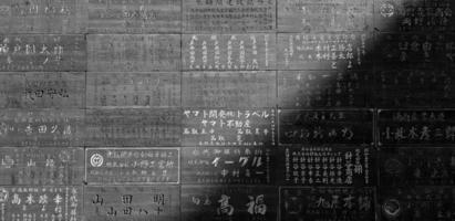 Japan - januari 2, 2023 veel woord of geschriften uitdrukken droefheid, denken over mensen wie ging dood Aan zwart blokken Bij Japans tempel in monochroom toon. Aziatisch mijlpaal voor toerist reizen en religie foto