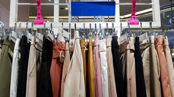 kleurrijk van vrouwen broek hangende Aan plastic hangers voor uitverkoop Bij mode op te slaan of vrouw accessoires winkel. katoen ontwerp. foto