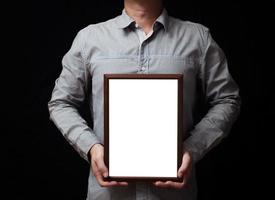 een blanco diploma of een mockup certificaat in de hand- van een Mens werknemer vervelend overhemd Aan zwart achtergrond. de verticaal afbeelding kader is leeg en de kopiëren ruimte. foto