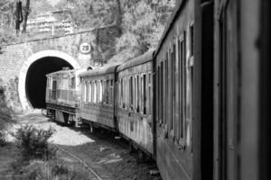 shimla, himachal pradesh, india - 14 mei 2022 - speelgoedtrein kalka-shimla route, bewegend op de spoorlijn naar de heuvel, speelgoedtrein van kalka naar shimla in india tussen groen natuurlijk bos foto