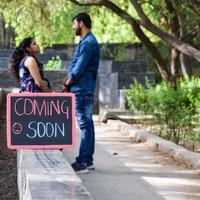 indiase paar poseren voor zwangerschaps baby shoot. het paar poseert in een gazon met groen gras en de vrouw pronkt met haar babybuil in de Lodhi-tuin in New Delhi, India foto