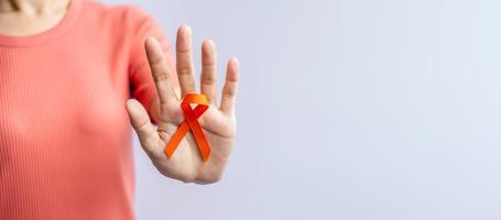 oranje lint voor leukemie, nierkankerdag, wereld multiple sclerose, crps, zelfverwondingsmaand. gezondheidszorg en woord kanker dag concept foto