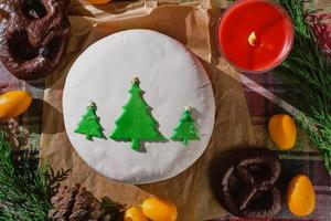 nog steeds leven van Kerstmis voedsel met fruitig Engels taart versierd met Spar bomen, gedekt met marsepein. traditioneel Kerstmis taart of pudding, Aan de achtergrond van Kerstmis decoraties, top visie foto