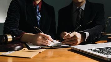 zaken en advocaten bespreken contractpapieren met koperen schaal op bureau in kantoor. wet, juridische diensten, advies, rechtvaardigheid en wet concept foto met film grain effect