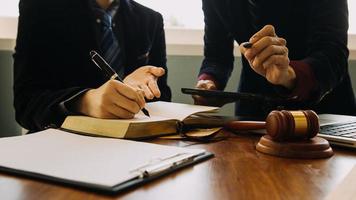 zaken en advocaten bespreken contractpapieren met koperen schaal op bureau in kantoor. wet, juridische diensten, advies, rechtvaardigheid en wet concept foto met film grain effect