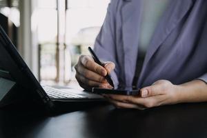 Aziatisch collega's Mens en vrouw bespreken en werken met laptop computer Aan kantoor bureau in de kantoor foto