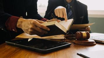 zaken en advocaten bespreken contractpapieren met koperen schaal op bureau in kantoor. wet, juridische diensten, advies, rechtvaardigheid en wet concept foto met film grain effect