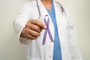 Aziatisch vrouw dokter met Purper lint, teken van alzheimer ziekte dag, alvleesklier kanker, epilepsie, lupus. foto