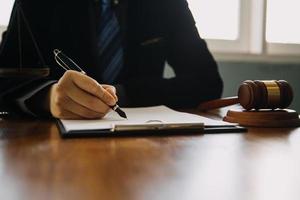 zaken en advocaten bespreken contractpapieren met koperen schaal op bureau in kantoor. wet, juridische diensten, advies, rechtvaardigheid en wet concept foto met film grain effect